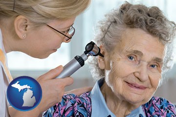 a otolaryngologist examining the ear of a patient - with Michigan icon