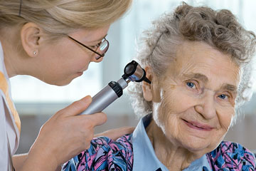 a otolaryngologist examining the ear of a patient